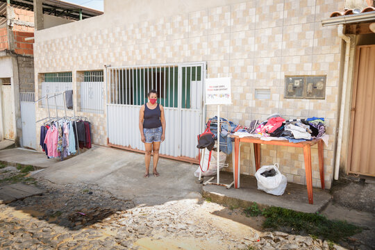 Mulher solid&aacute;ria oferece roupas gratuitas para pessoas carentes em frente de sua casa, em Guarani, Minas Gerais, Brasil