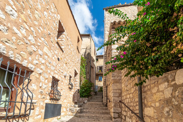 Fototapeta na wymiar A narrow alley and staircase in a residential area of the medieval walled village of Tourrettes Sur Loup in the Alpes-Maritimes section of France.
