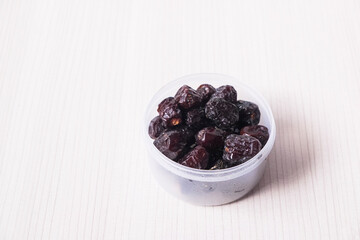 Close Up Image Of Dried Dates Or Kurma On White Table.