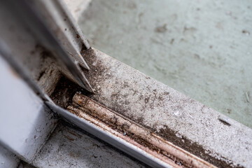 Dirty aluminum frame window sill that needs cleaning