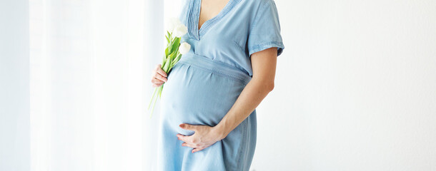 Pregnant woman holding spring flowers