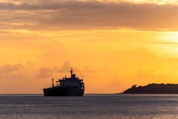 Fototapeta na wymiar Sunset over an oil tanker off the ocast of Bali near Padang Bai in Indonesia