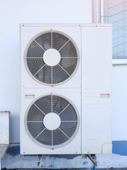 Condenser unit or compressor outside home or residential building. Unit of central air conditioner...
