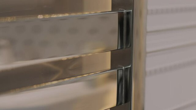 Closeup heated towel rail, dryer in bathroom, metal pipes, metal batteries