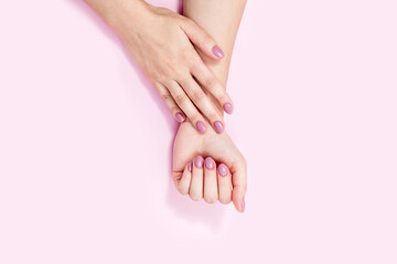 Obraz na płótnie Canvas Beautiful female hands on a pink background. 