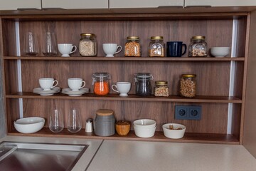 Fototapeta na wymiar Organization of space the kitchen concept.Smooth shelves with glass jars.