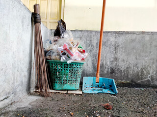 Rubbish, dustpans and brooms, dirty environment background.