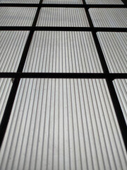 metal grid background and window light background from bed. Light from behind the iron bars of the window box. 