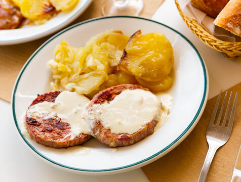 Delicious fried turkey escalopes with spicy Roquefort cheese sauce and side dish of potatoes