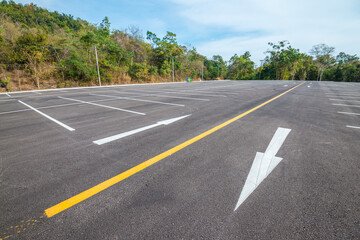 Obraz premium Empty space outdoor asphalt parking lot in national park. Large car park with white line paint on mountain hill in sunny day blue sky background. 