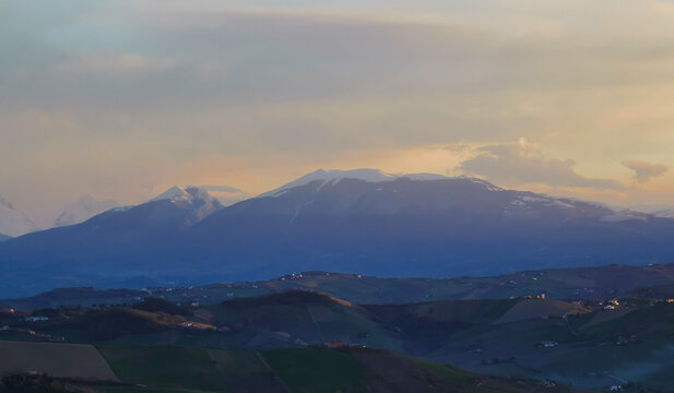 Tramonto di luce e foschia sulle cime innevate dell&rsquo;appennino