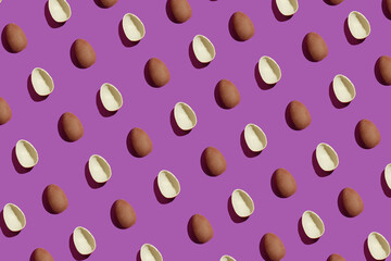 Broken chocolate eggs on a purple background. Pattern. Easter concept