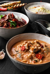 Various soups, traditional beetroot soup with meat, soups with mushrooms, seafood on dark wooden background. Hot dinner, close up