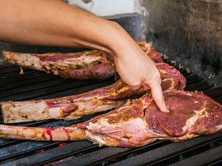 Tomahawk rib beef steak on hot black grill with flames