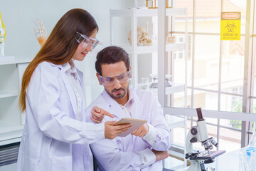 Fototapeta premium Doctor and microbiologist with vacuum tubes for samples with COVID 19 infection atypical pneumonia virus in laboratory