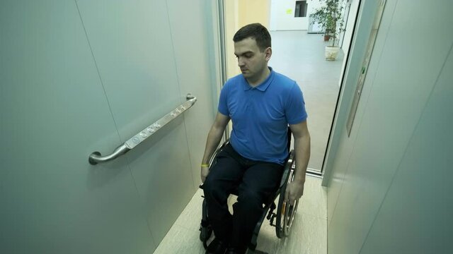 A man in a wheelchair enters the elevator. A person with a disability rides an elevator.