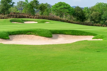 Fotobehang Golfbaan, Prachtig landschap van een golfbaan met bomen en groen gras © CasanoWa Stutio