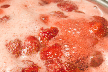 Red strawberry  cooked in sugar syrup. Process of making jam marmalade at home.