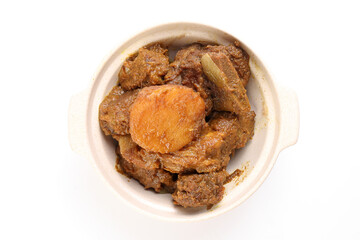 Asian style Beef bhuna dry curry with potato in ceramic bowl over white background