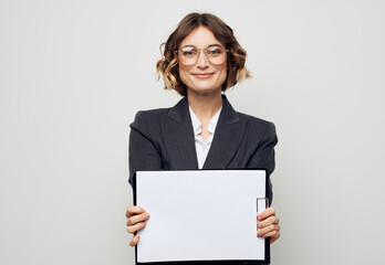 Naklejka premium Woman in business suit with white sheet of paper at work glasses mockup