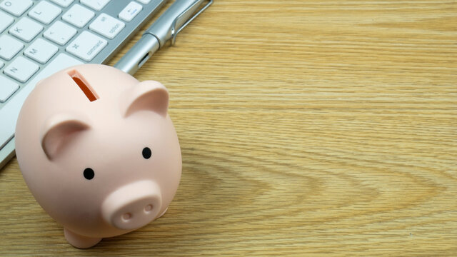 A piggy bank on wood table for  Finance or saving money business content.