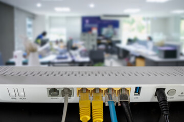 Internet router device connected with blue yellow and white LAN cable place on wooden  table....
