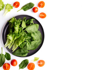 Bowl of fresh green salad leaves, lettuce, spinach and red cherry tomatoes cuts
