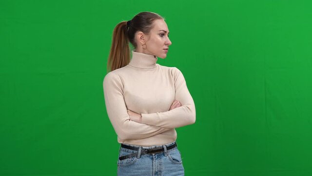 Nervous woman looking around with worried facial expression on green screen. Middle shot of stressed Caucasian lady gets scared at chromakey background. Panic and fear concept.