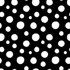 Vector seamless pattern of white hand-drawn circles polka dot isolated on a black background