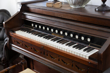 A Slight Downward, Close Up View, of an Antique Pump Organ with Stops Pull Knobs