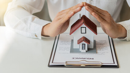 A young man who has his hand covered the house is a real estate and property security and insurance...