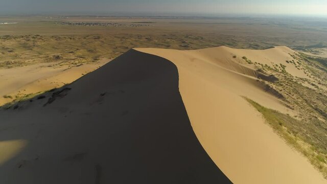 Fast motion aerial backwards grand  Sarykum Dagestan desert highest sandy yellow dune. Amazing wilderness on plain. Best nature Caucasus landmark Open space, horizon. Russia. Summer sunny travel film