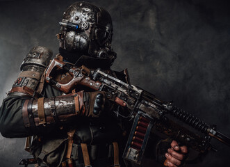 Fototapeta na wymiar Apocalyptic armoured hunter with riffle in dark background