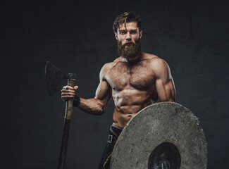 Obraz na płótnie Canvas Northern warrior with axe and shield in dark background