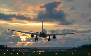 Airplane is landing during sunrise
