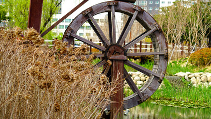 a waterwheel by a stream in the park