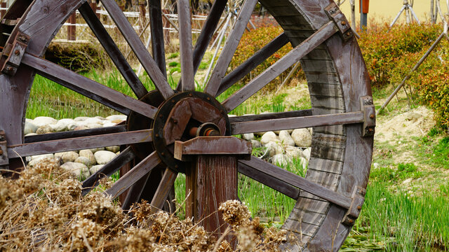 a waterwheel by a stream in the park