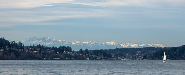Fototapeta na wymiar The Olympic Mountain range and Gig Harbor as seen from the Tacoma Narrows waterway.