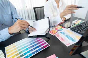 Graphic designer or creative working together coloring using graphics tablet and a stylus at desk...