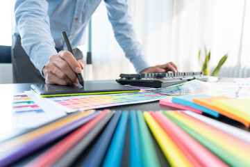 interior designer or creative graphic designer working on project architectural with colour samples with work tools and equipment for selection in office