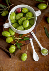 Olive oil and olive branch on black background