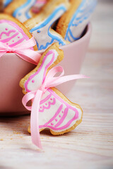 Easter baking background of frosted cookie in shape of rabbit on white wooden table