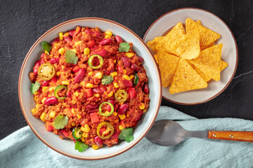Mexican dinner, chili con carne with nachos and a spoon