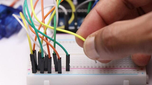Connecting jumper wires to solderless breadboard which shows concept of electronics project making