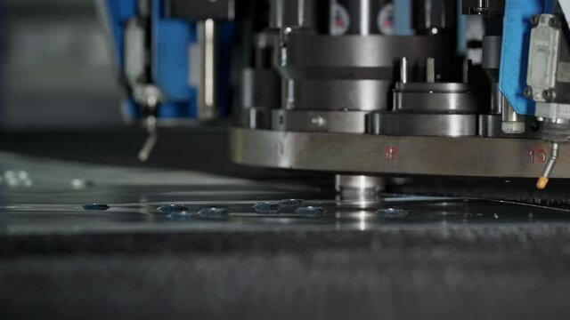 An Industrial Factory. Manufacturing. A Part of the Highly Complex Vertical Stamping Machine is Slowly Pressing Down on the Metal Sheet. Heavy machinery. Steel. Production Process. Conveyor Line.