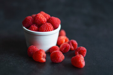 Ripe Red raspberry in a clay bowl on a black background. Photo of Red raspberry in clay bowl on table. High resolution product. Ripe berries bowl. Summer sweet fruits.