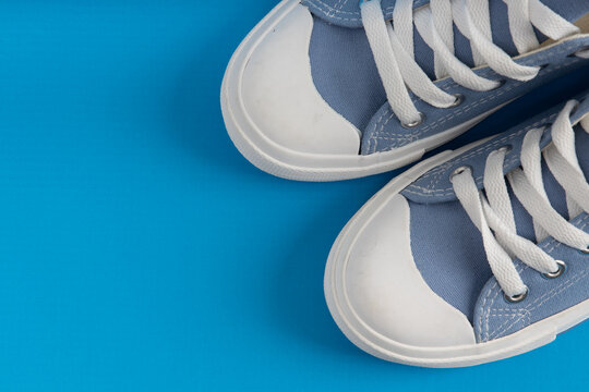 Pair Of New Blue Sneakers, Sport Shoes On Blue Background. Top Down View