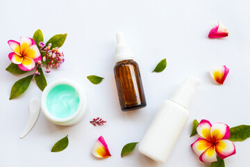 intensive whitening serum, lotion and night cream mask health care for skin face beauty of woman with flowers arrangement flat lay style on background wooden