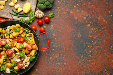Frying pan with tasty vegetables and chicken on grunge background