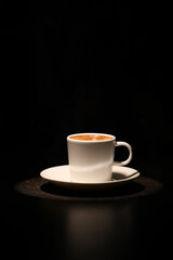 Cup with hot coffee on dark background
